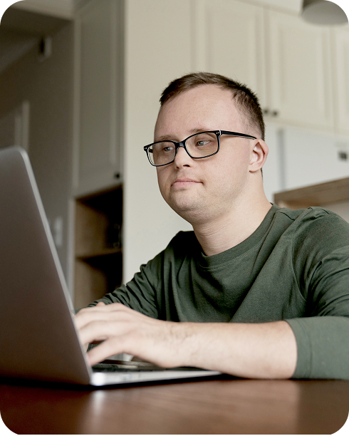 Hombre con discapacidad intelectual concentrado trabajando en una computadora portátil
